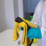 Cleaner disinfecting an office phone